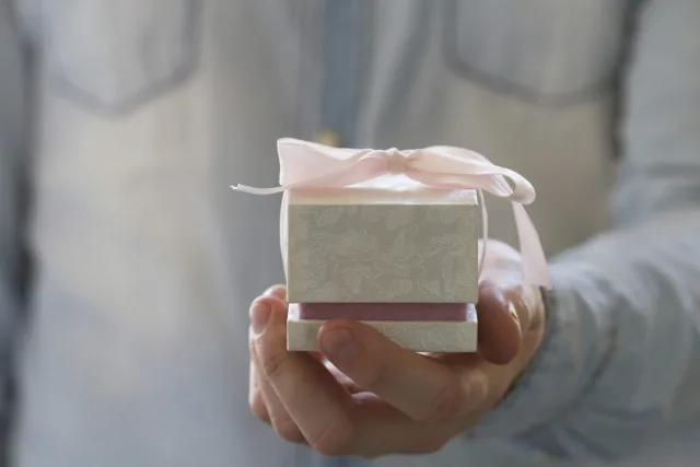 Man hand holding engagement ring in the white gift box 000071174083 Full jpg